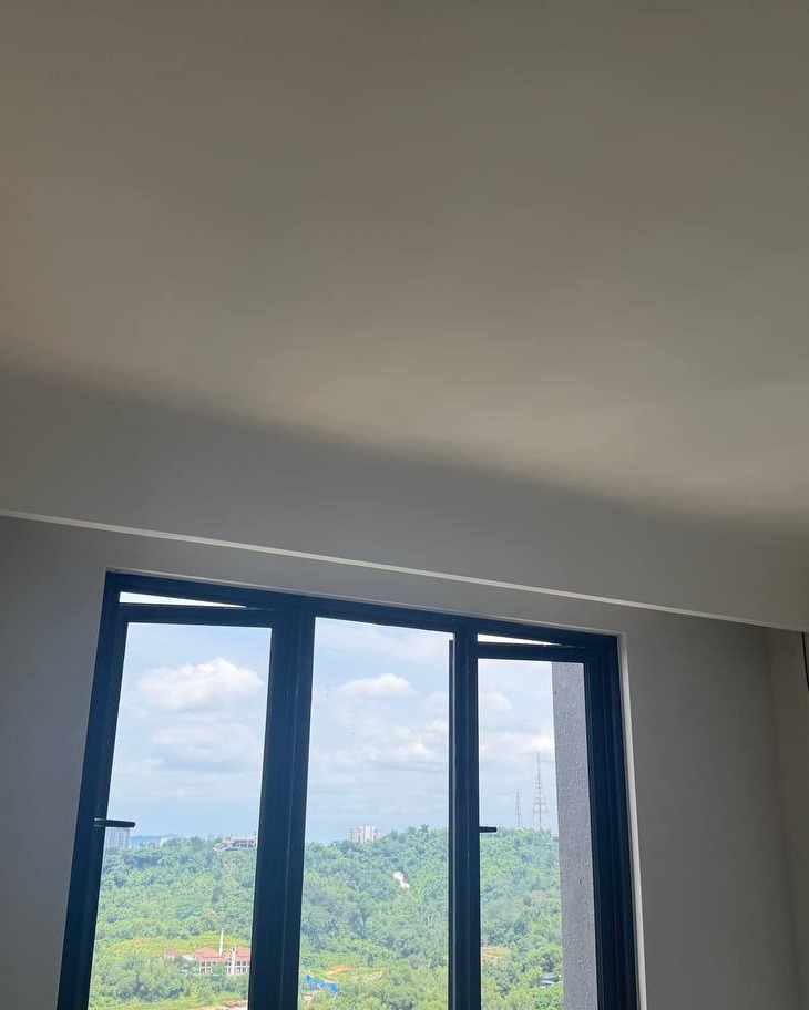 Bangsar Curved Ceiling with Concealed Lighting Cove Curved plaster ceiling with concealed cove lighting above black-framed window overlooking green hillside, Bangsar residential ceiling design
