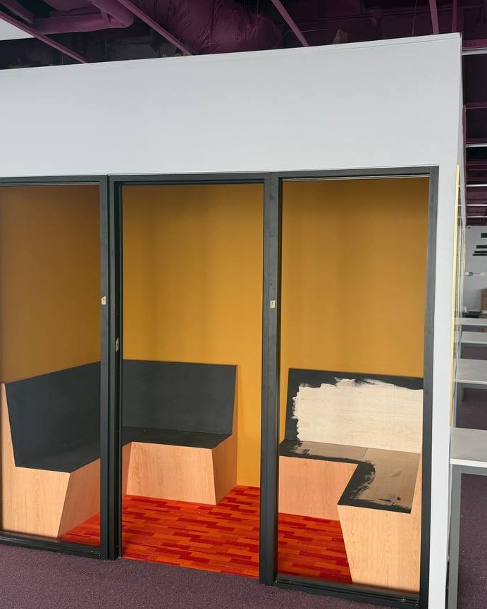 Soundproof Partition Booths with Plaster Ceiling – Brickfields Office Three soundproof partition booths with plaster ceiling bulkhead in Brickfields office, mustard yellow walls and black-framed openings above built-in wooden bench seating