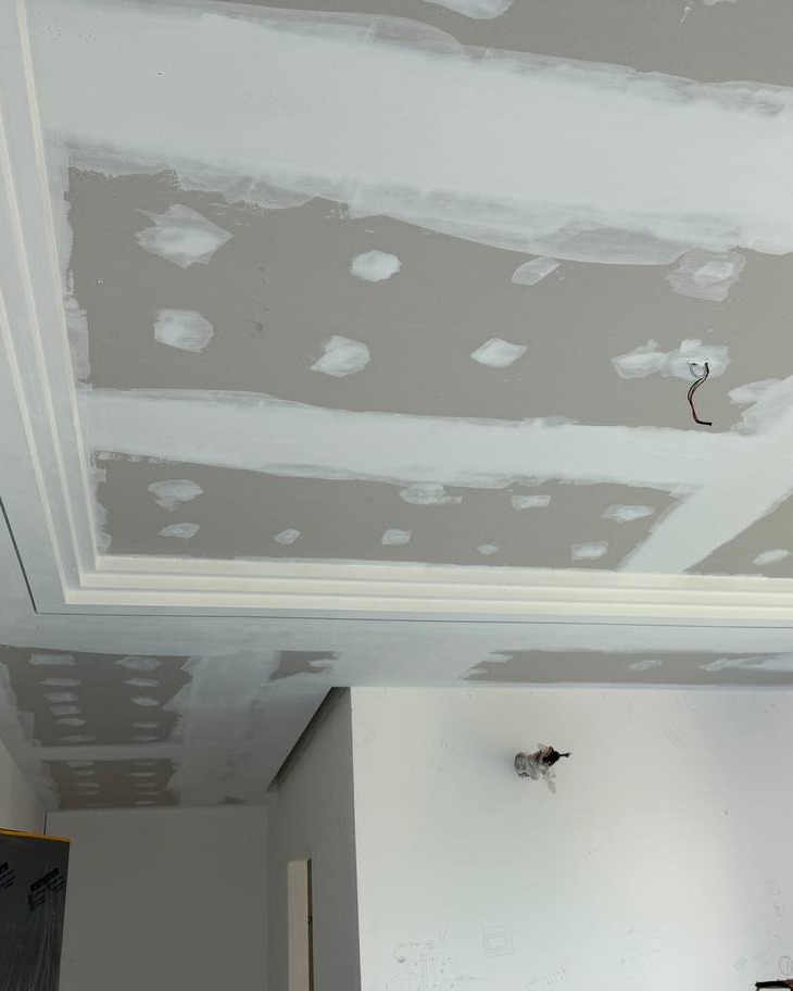 Cove Ceiling Panel Mid-Construction, Cyberjaya Plaster ceiling drop panel with cove lighting recess under construction, showing skim-coated joints and screw points, Cyberjaya residential staircase project