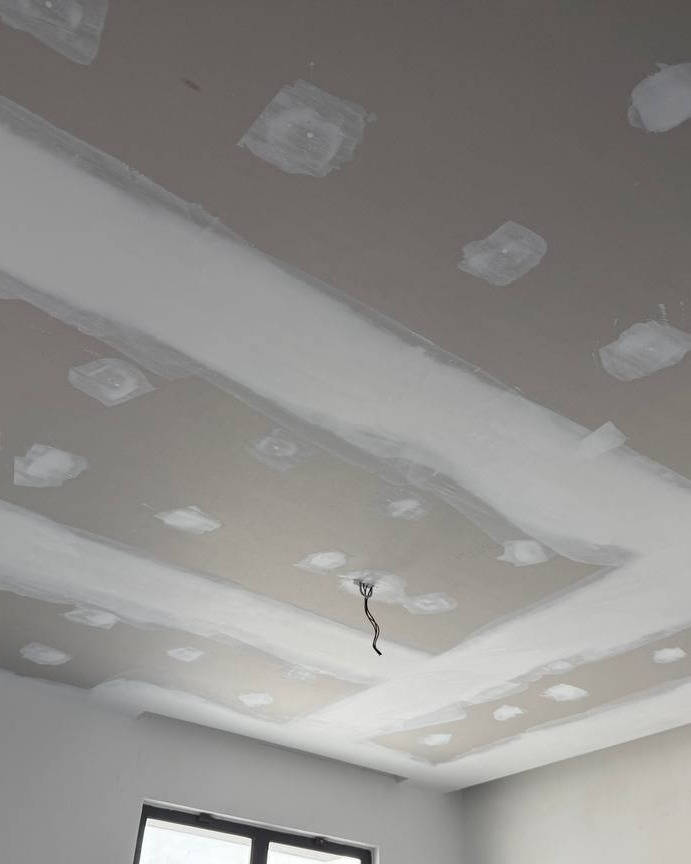 Plaster Ceiling with Cove Recess – Before Final Sanding Multi-level plaster ceiling with cove light recess and jointing filler patches over spotlight points, Cyberjaya residential staircase project