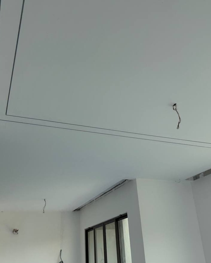 Plaster Ceiling with Cove Light Wiring Prep - Cyberjaya Freshly plastered ceiling in Cyberjaya home showing recessed cove light lines and hanging wire connectors ready for LED strip installation above staircase area