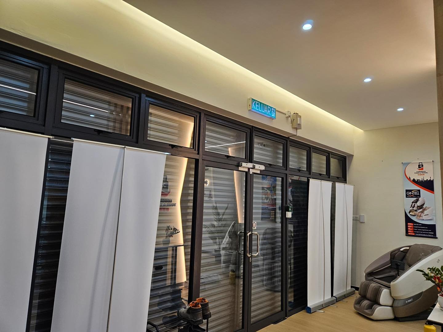 Shopfront Entrance with LED Ceiling Cove - Kepong Office LED cove lighting along the ceiling perimeter above glazed shopfront entrance doors and roller shutters, Longrich Tour & Travel office, Kepong