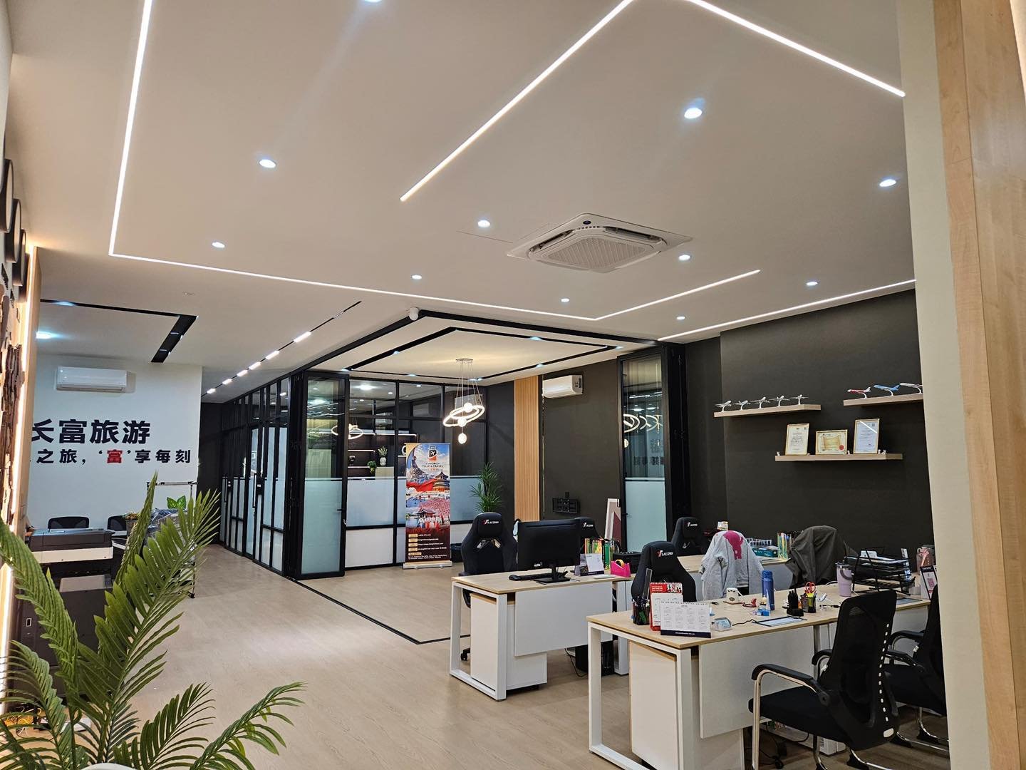 Square LED Ceiling Design Above Open-Plan Office - Kepong Square-in-square recessed LED ceiling design with downlights and aircon cassette unit above an open-plan office workstation area, glass partition walls to meeting room, Kepong office fit-out