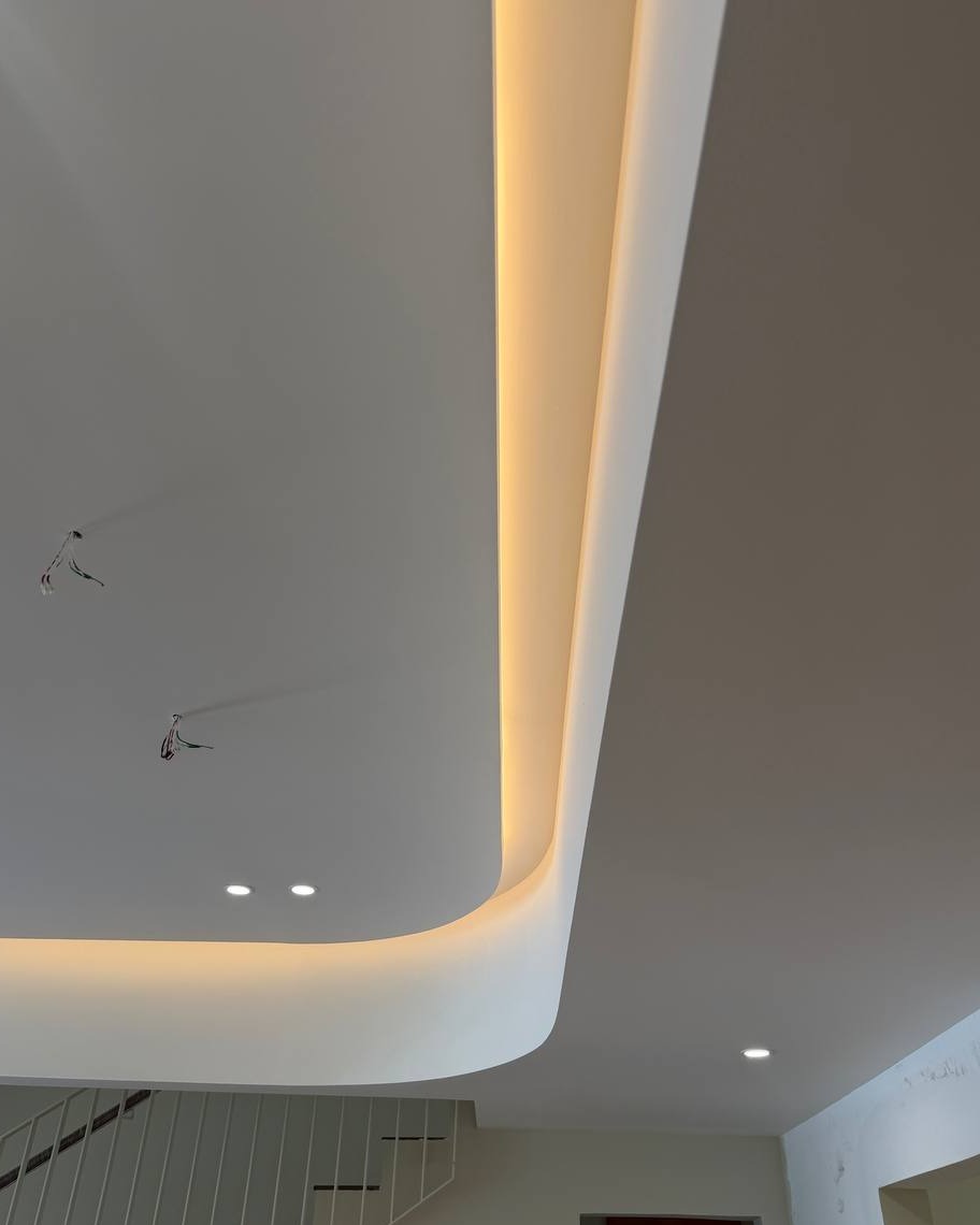 Curved Plaster Ceiling with Cove Lighting Above Staircase - Rawang Curved plaster ceiling with hidden cove lighting channel above a staircase in a Rawang residential ground floor, showing recessed LED downlights and pending pendant light wiring