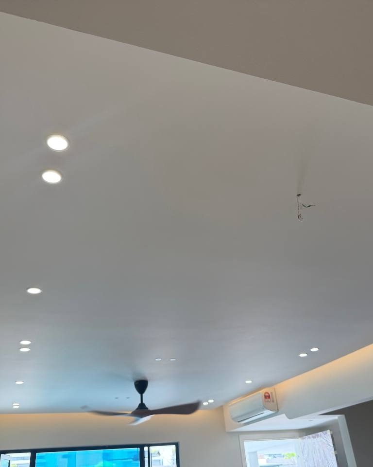 Curved Plaster Ceiling with Cove Lighting - Rawang Home Multi-level plaster ceiling with curved cove lighting edge, recessed downlights, exposed wiring point for ceiling fan, and wall-mounted air conditioner unit in Rawang residential ground floor renovation