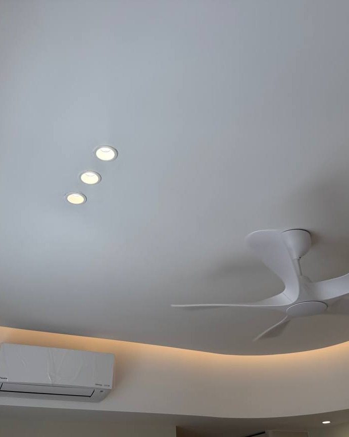 Curved Plaster Ceiling with LED Strip Lighting - Rawang Curved plaster ceiling in Rawang home with recessed LED downlights, modern white ceiling fan, and warm LED strip lighting concealed along the curved drop edge above an air conditioning unit