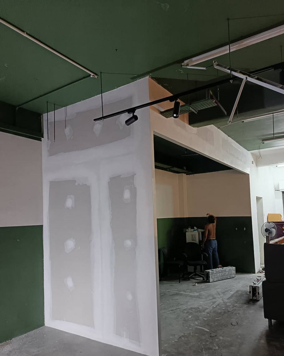 Plastered Partition Wall Entrance - Shah Alam Office Skim-coated drywall partition wall with plaster-filled screw joints forming an office entrance opening, installed under a green ceiling in Shah Alam office fit-out project