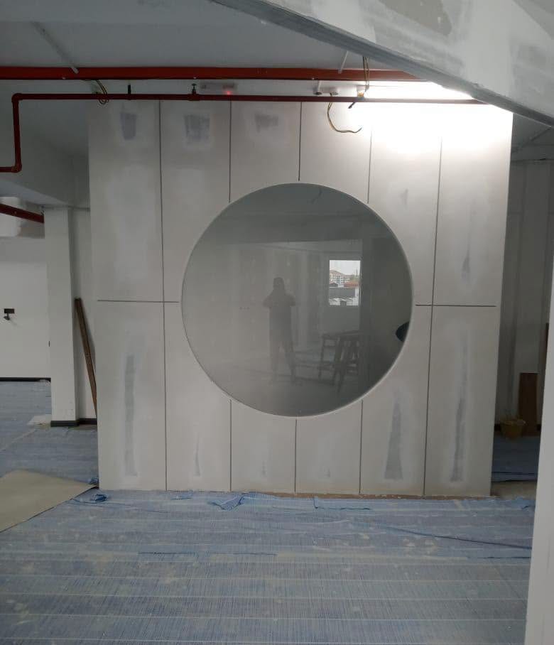 Round-Window Partition Screen – Shah Alam Drywall partition screen with a large round clear-glass window during construction, Shah Alam renovation