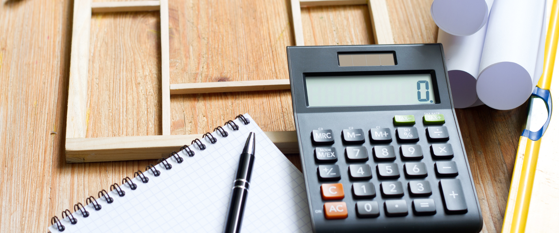 Calculator and blueprints on a desk representing free site visit, consultation, and quotation services in Klang Valley.