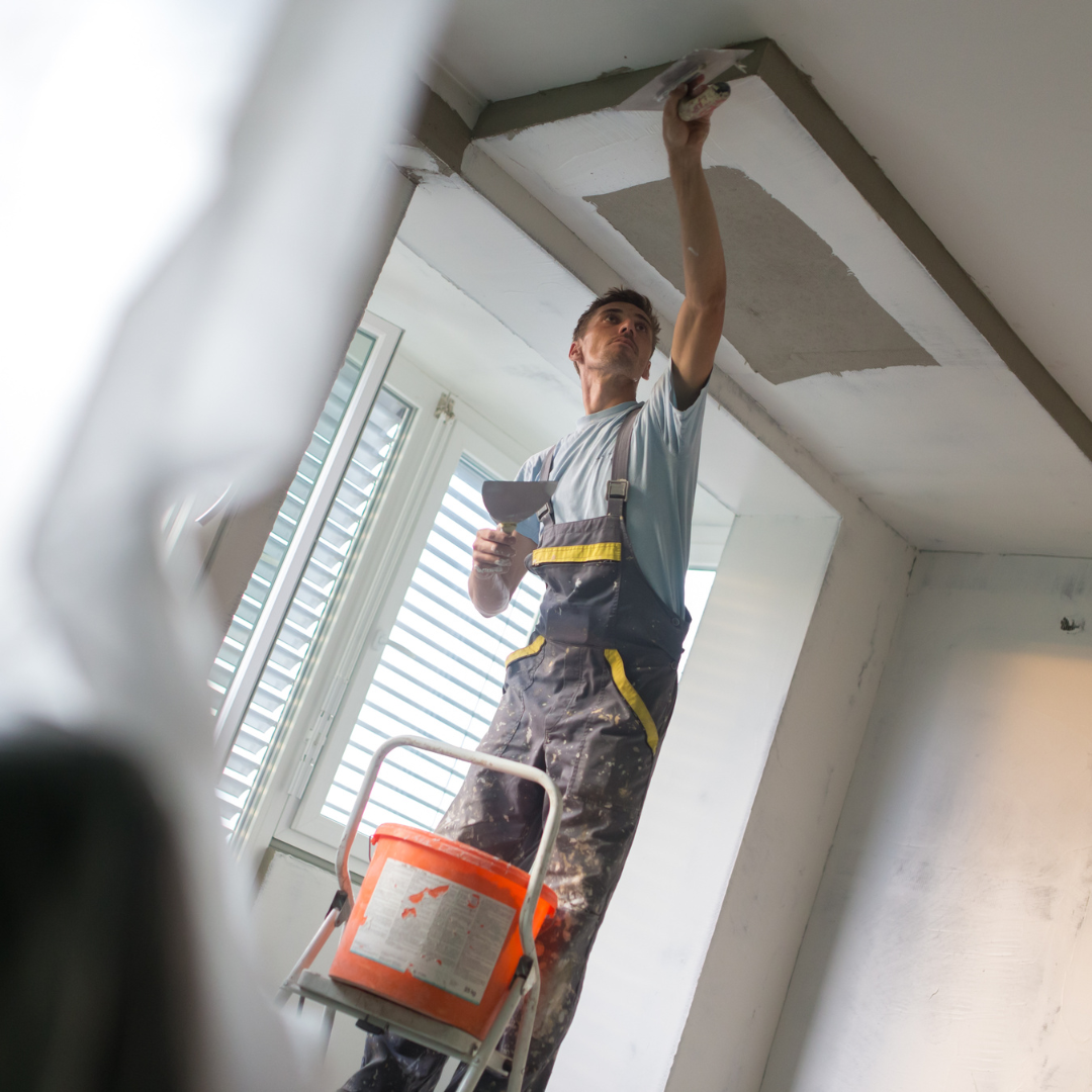 Worker installing plaster ceiling with precision