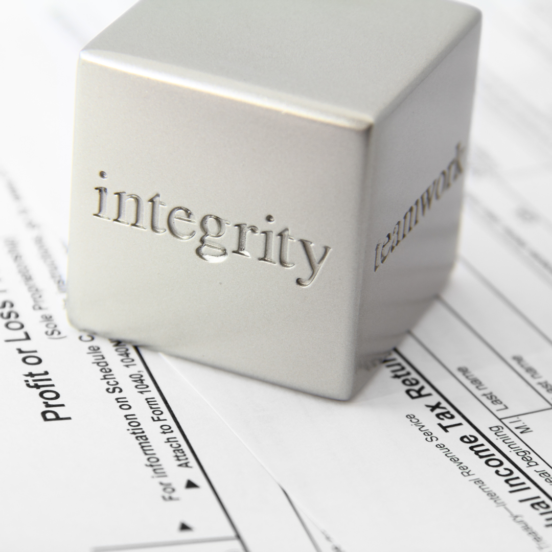 Integrity and teamwork concept with metal cube on financial documents
