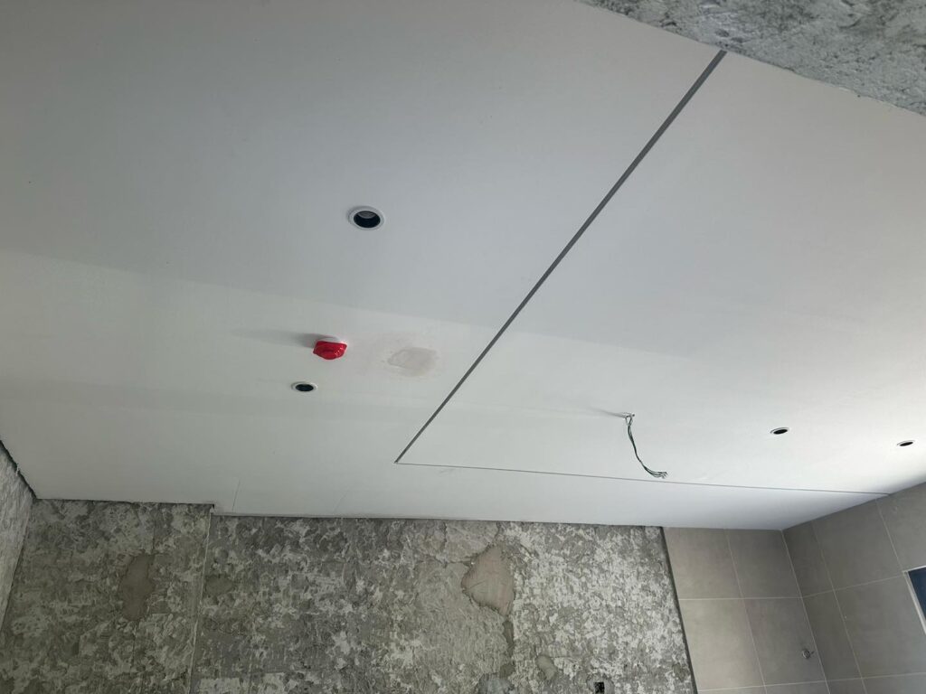 Project in progress: Bathroom plaster ceiling with concealed wiring, spotlight cutouts, and a neat access panel – enhancing utility without compromising style.