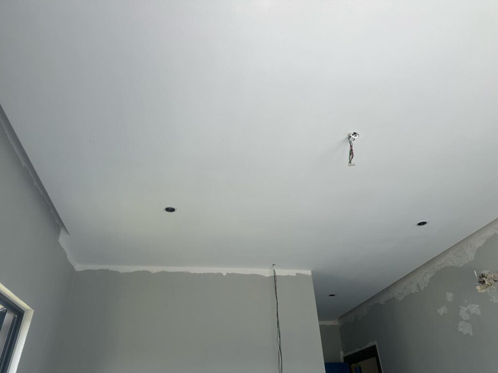 Ongoing plaster ceiling project in Cyberjaya featuring lighting and electrical wiring setup before paint touch-up.