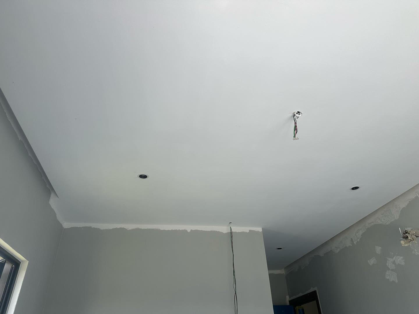 Ongoing plaster ceiling project in Cyberjaya featuring lighting and electrical wiring setup before paint touch-up.