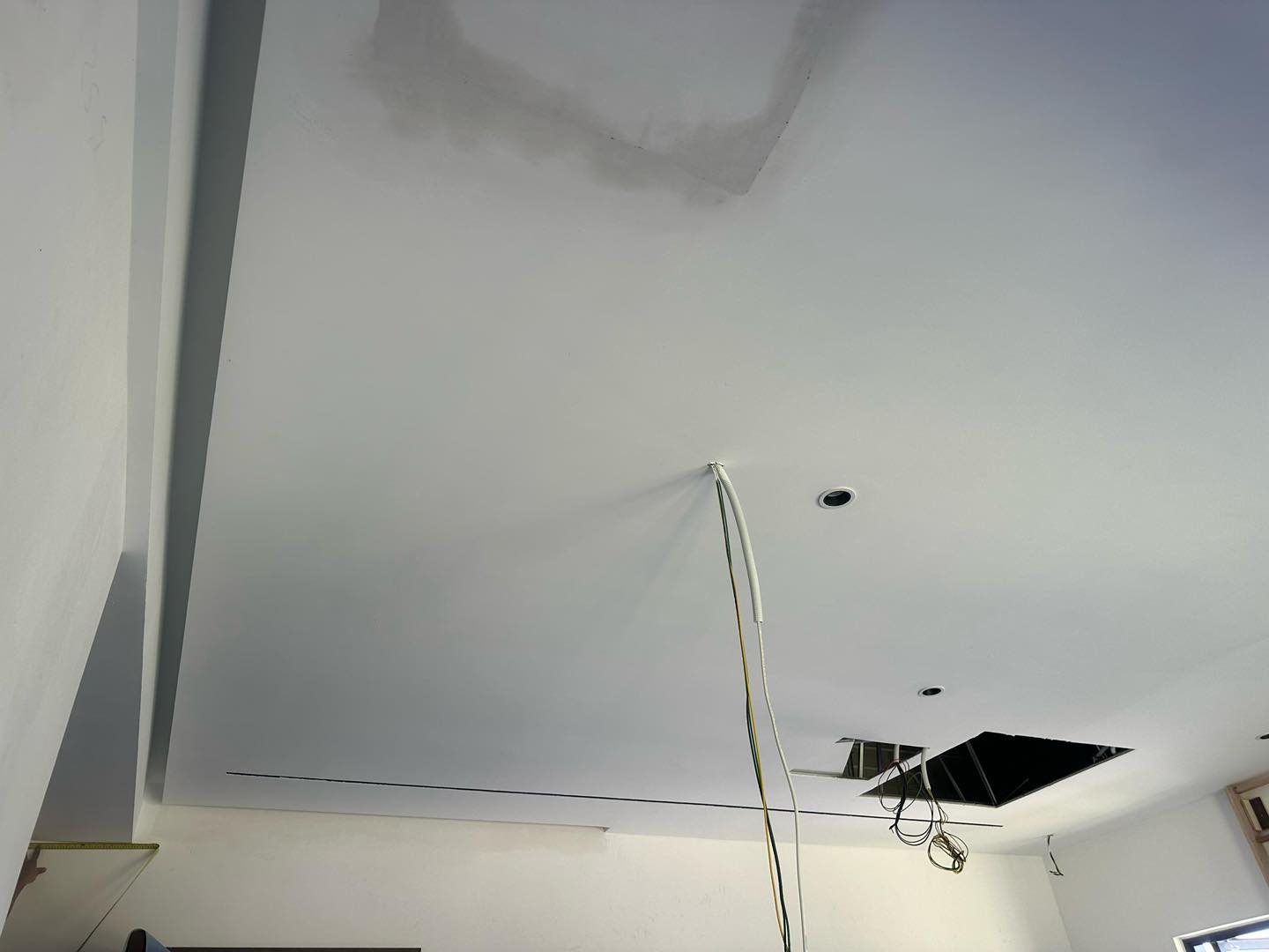 Wiring installation stage of plaster ceiling renovation in Cyberjaya, including recessed lighting setup and ceiling maintenance access panel.