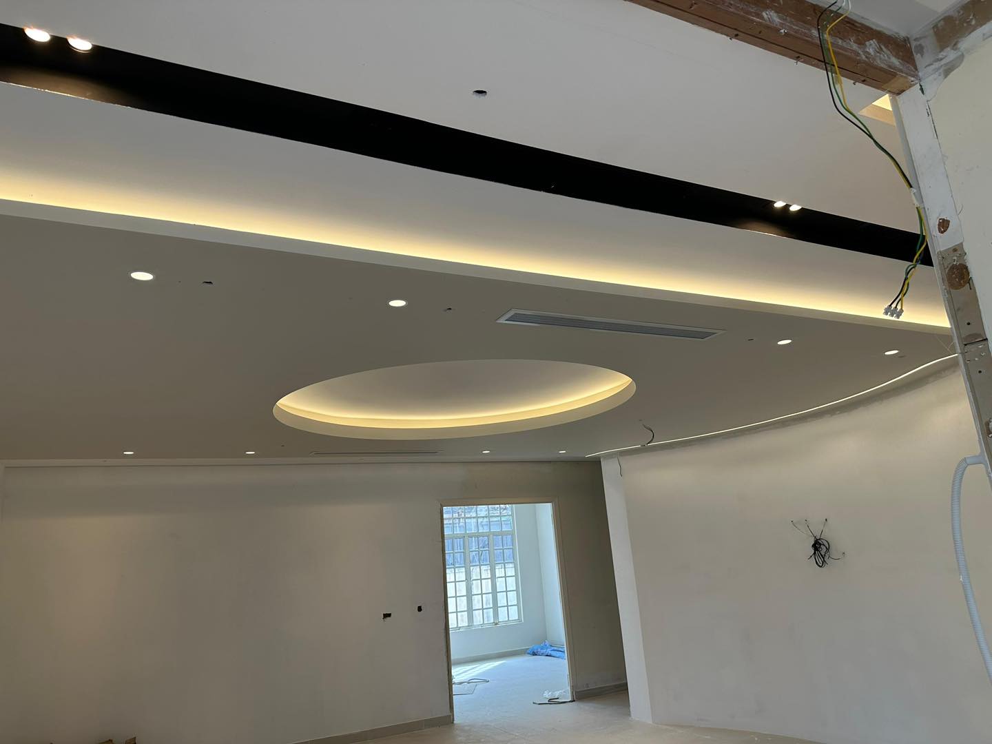 Work in progress: smooth circular ceiling center framed by layered LED cove lights. Ideal for stylish living or meeting areas.