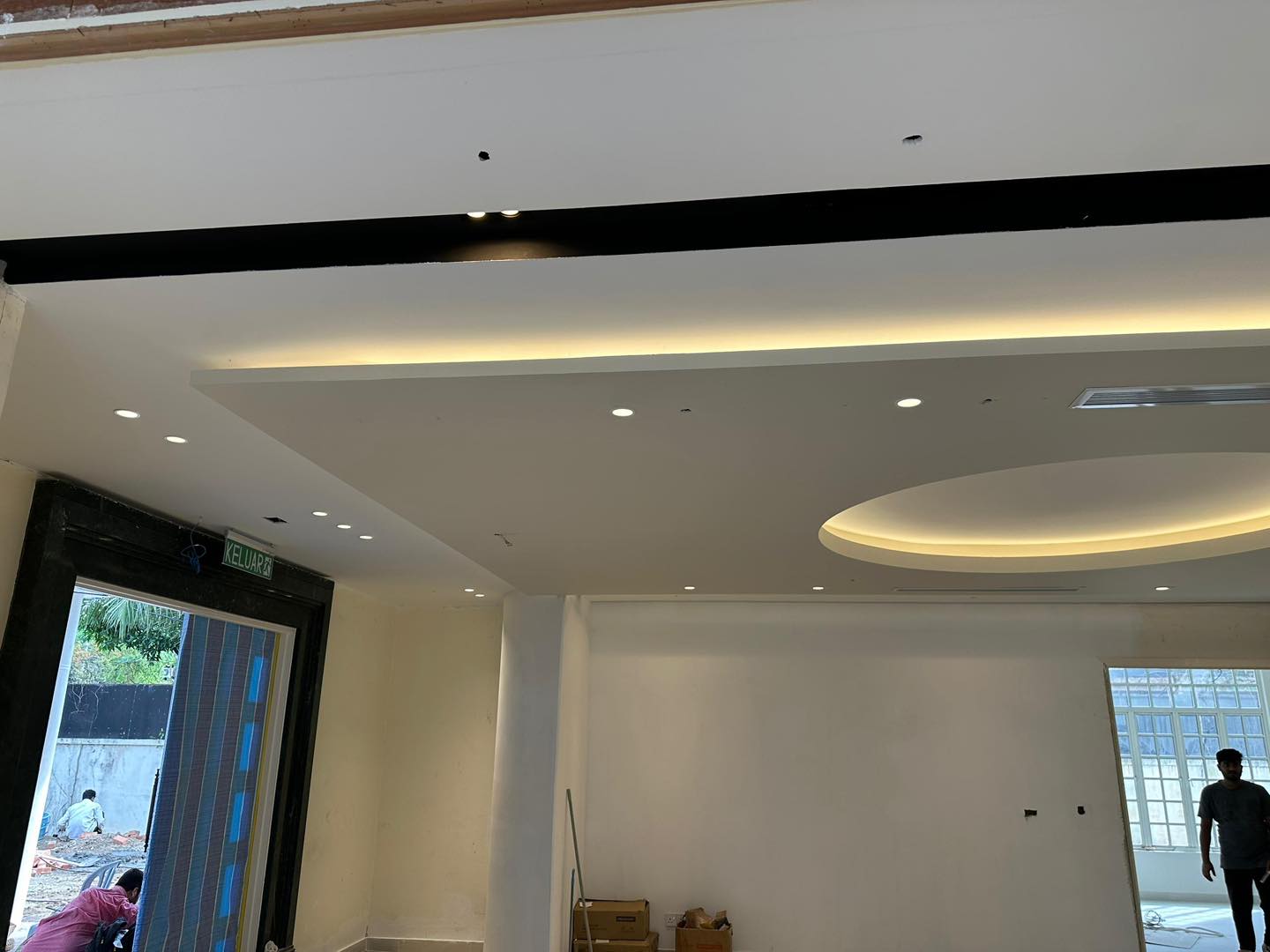 Installation in progress: layered ceiling design with modern recessed round feature and warm cove lighting. A premium touch for KL interiors.