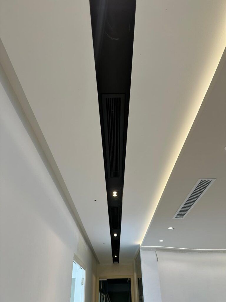 KL project completed: streamlined ceiling with black linear vent and warm LED cove lighting.