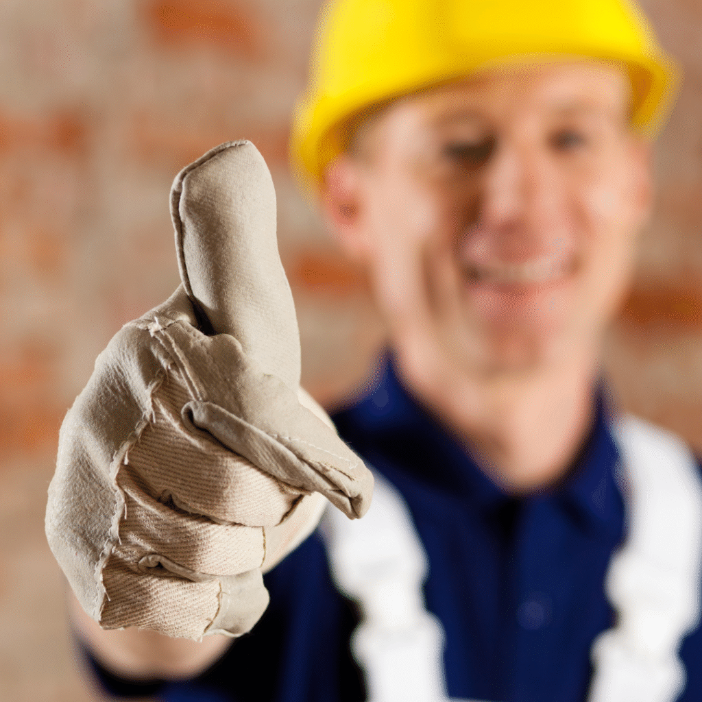 Construction worker in safety gear giving a thumbs-up gesture