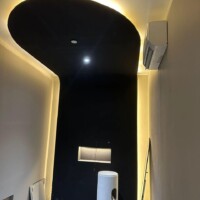 Curved plaster ceiling with a floral centerpiece in a modern lobby.