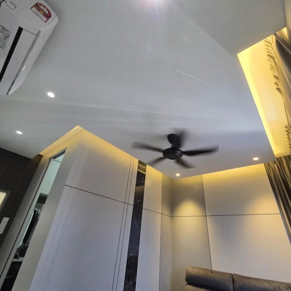 Customized plaster ceiling in a KL bedroom, enhanced with warm ambient cove lighting and ceiling fan for a cozy modern interior.