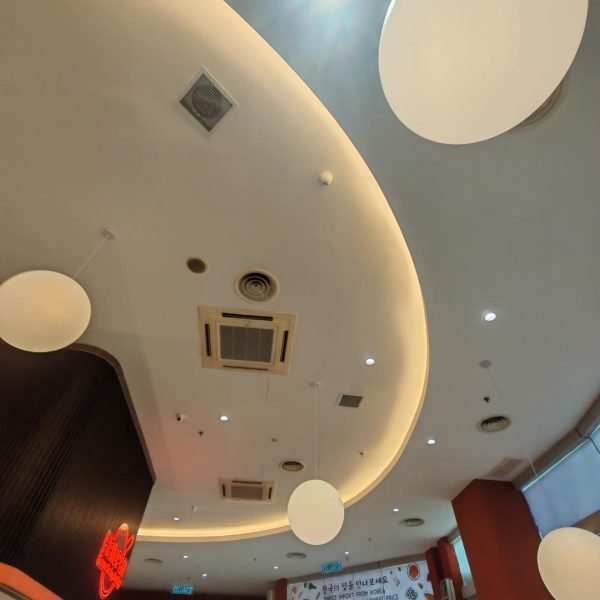 Unique commercial plaster ceiling installation in Kuala Lumpur, featuring curved layouts, round lighting panels, and cove lighting for a modern interior touch.