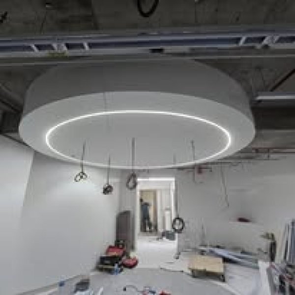 A stunning circular plaster ceiling centerpiece with recessed LED strip lighting, currently under construction at a commercial project site.
