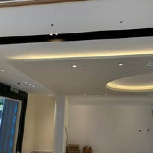 A stylish plaster ceiling design featuring subtle cove lighting and LED recessed lights, bringing warmth and elegance to the living room space.
