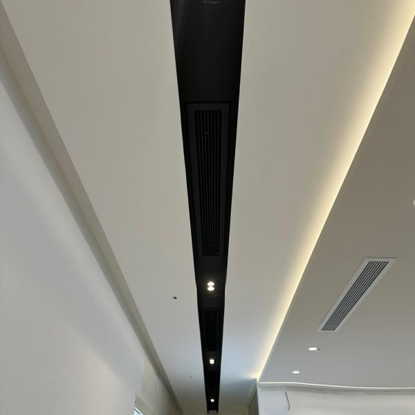 KL project completed: streamlined ceiling with black linear vent and warm LED cove lighting.